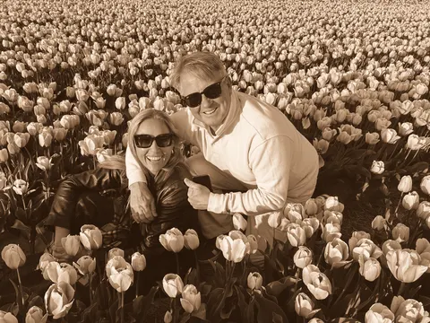 Kneeling together in a field of tulips in flower
