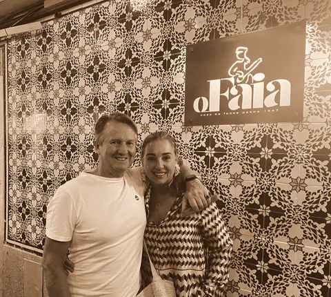 In front of a wall of patterned tiles outside a restaurant
