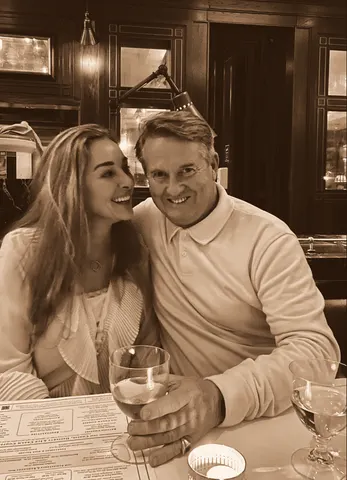 Cheek to cheek over a table in a wood-panelled dining car