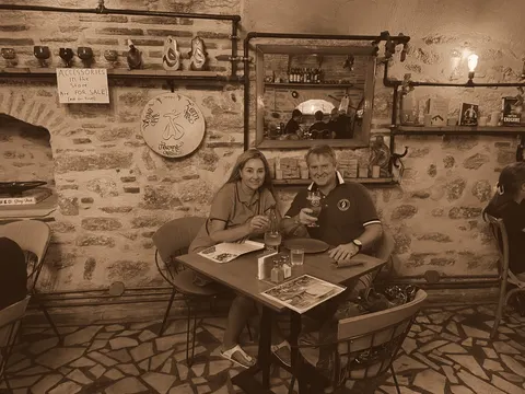 A small table in a stone-walled bar hung with bric-a-brac